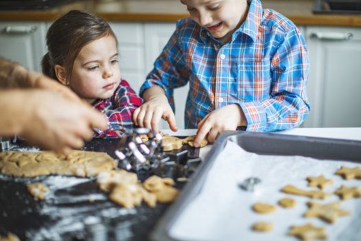 Family making christmas cookies, young child using fine motor skills