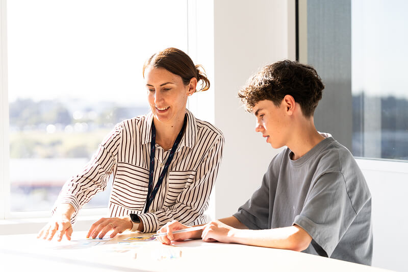 a woman and boy in a professional setting, sitting and talking